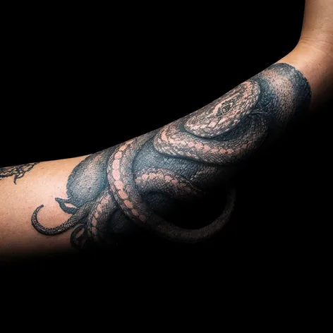 Snake around arm tattoo